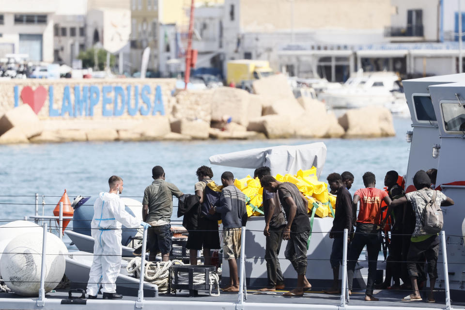 Rescued migrants stand in a boat of the Italian Finance Police before disembarking at the port of the Sicilian island of Lampedusa, southern Italy, Monday, Sept. 18, 2023. The Italian Cabinet met Monday to adopt new measures to crack down on migration after the southern island of Lampedusa was again overwhelmed by a wave of arrivals from Tunisia and the migration issue again took center stage in Europe with talk of a naval blockade. (Cecilia Fabiano/LaPresse via AP)