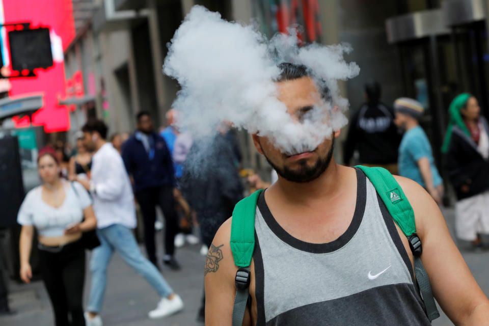 A man uses a vape as he walks on Broadway in New York City, U.S., September 9, 2019. REUTERS/Andrew Kelly