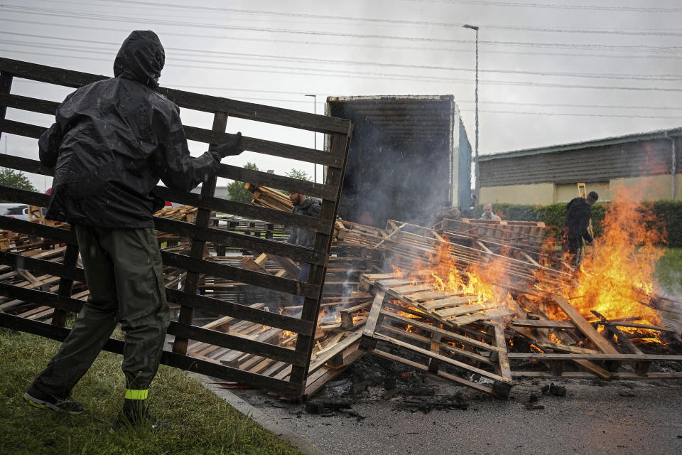 Prison workers burn wooden pallets during a protest in front of the Corbas prison, outside Lyon, France, Wednesday, May 15, 2024 . A massive manhunt was underway in France on Wednesday for an armed gang that ambushed a prison convoy, killing two prison officers, seriously injuring three others and springing the inmate they were escorting. (AP Photo/Laurent Cipriani)