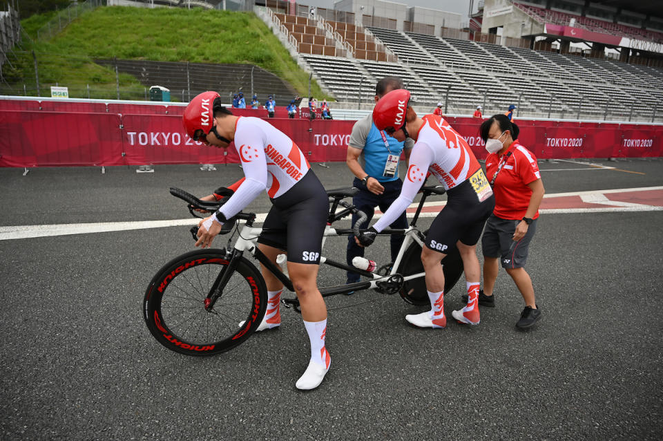 Singapore cyclists Ang Kee Meng (left) and Steve Tee stop for a technical problem in the men's time trial road cycling event at the 2020 Tokyo Paralympics. (PHOTO: Sport Singapore)