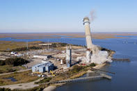 The smokestack at the former B.L. England Generating Station, a coal and oil burning power plant in Upper Township, N.J., is toppled during a control demolition on Thursday, October 26, 2023. The site will be redeveloped as a mixed-use residential and commercial project, and a nearby electrical substation will be used to connect New Jersey's soon-to-come offshore wind farms with the electrical grid. (AP Photo/Ted Shaffrey)