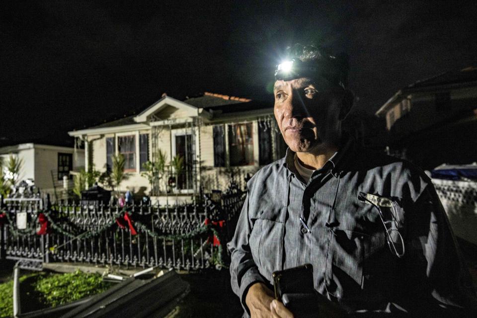 With no electricity, Roy Fitch uses a head lamp to survey tornado damage to his home on MacArthur Ave in Gretna, La., in Jefferson Parish neighboring New Orleans, Wednesday, Dec. 14, 2022. AP Photo/Matthew Hinton)