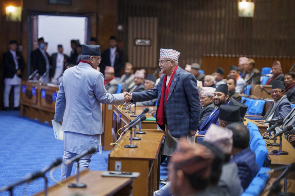 Nepalese Prime Minister Pushpa Kamal Dahal, left, shakes hands with Khadga Prasad Oli, the chairman of the Communist Party of Nepal (Unified Marxist–Leninist) before the vote of confidence in Nepal's parliament in Kathmandu, Nepal, Tuesday, Jan. 10, 2023. Nepal's newly appointed prime minister has secured the vote of confidence in parliament with support from both members of his coalition parties and the opponent groups.(AP Photo/Niranjan Shrestha)