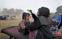 Ruby Khan helps her 7-year-old son Farmaan get ready for school in New Delhi, India, on Jan. 18, 2019. (AP Photo/Altaf Qadri)