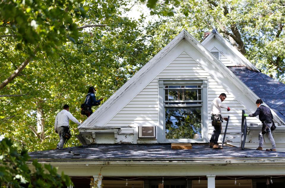 Roofers from Southern Roofing and Renovations put a new roof on U.S. Army veteran Larry Rottmann's house on Wednesday, Oct. 18, 2023.