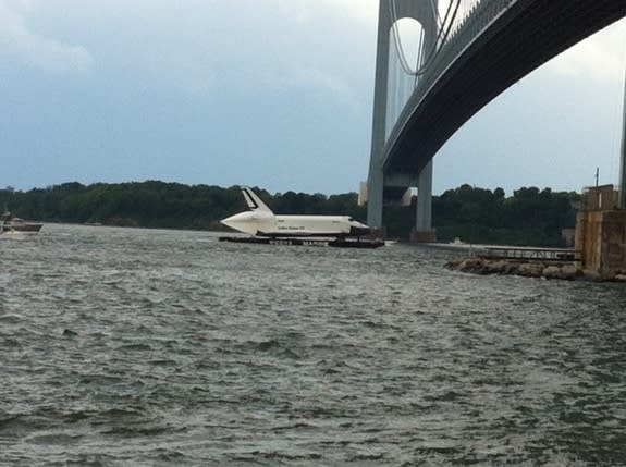 A barge carrying NASA's space shuttle Enterprise prototype passes beneath a bridge in the New York Harbor during a trip from John F. Kennedy airport to a New Jersey port during delivery on June 3, 2012. Enterprise is being delivered to the Intr