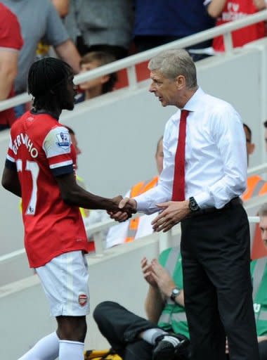 Arsenal's manager Arsene Wenger shakes hands with striker Gervinho (L) after he is substiuted during their English Premier League football match against Southampton at The Emirates Stadium in north London