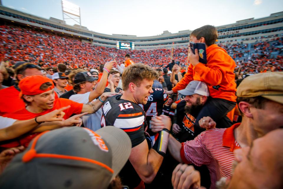 Oklahoma State’s Gunnar Gundy (12) celebrates with fans on the field after a Bedlam college football game between the Oklahoma State University Cowboys (OSU) and the University of Oklahoma Sooners (OU) at Boone Pickens Stadium in Stillwater, Okla., Saturday, Nov. 4, 2023.