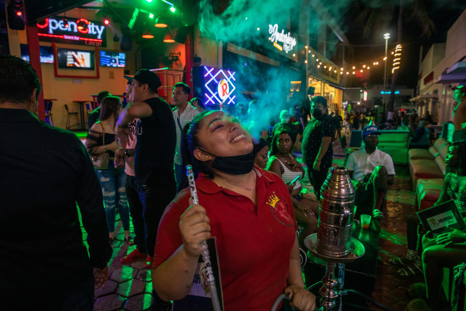 Tourists smoke hookah at local bars in the Cancún’s popular nightlife district on Oct. 17. After a drop in travel because of the pandemic, American tourists are again flooding the city’s streets and beaches.<span class="copyright">Claudia Guadarrama—Magnum Foundation for TIME</span>