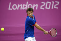 LONDON, ENGLAND - JULY 30: Gilles Simon of France plays a backhand during the Men's Singles Tennis match against Grigor Dimitrov of Bulgaria on Day 3 of the London 2012 Olympic Games at the All England Lawn Tennis and Croquet Club in Wimbledon on July 30, 2012 in London, England. (Photo by Jamie Squire/Getty Images)