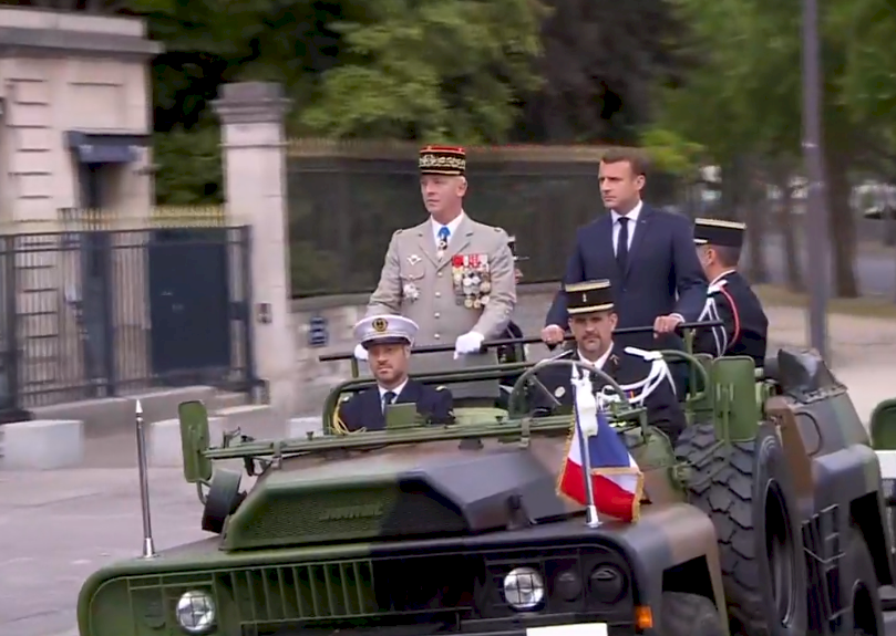 法國總統馬克宏(Emmanuel Macron)站在協和廣場1輛軍用吉普車上，小規模的點閱保持社交距離的部隊。(圖擷自馬克宏臉書)