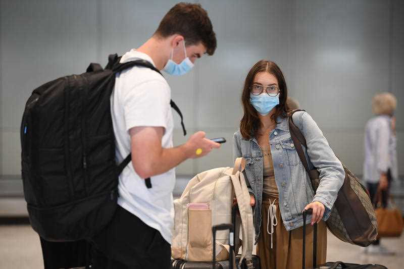 Passengers collect baggage after arriving on Flight QF444 from Melbourne at Sydney Domestic Airport in Sydney.