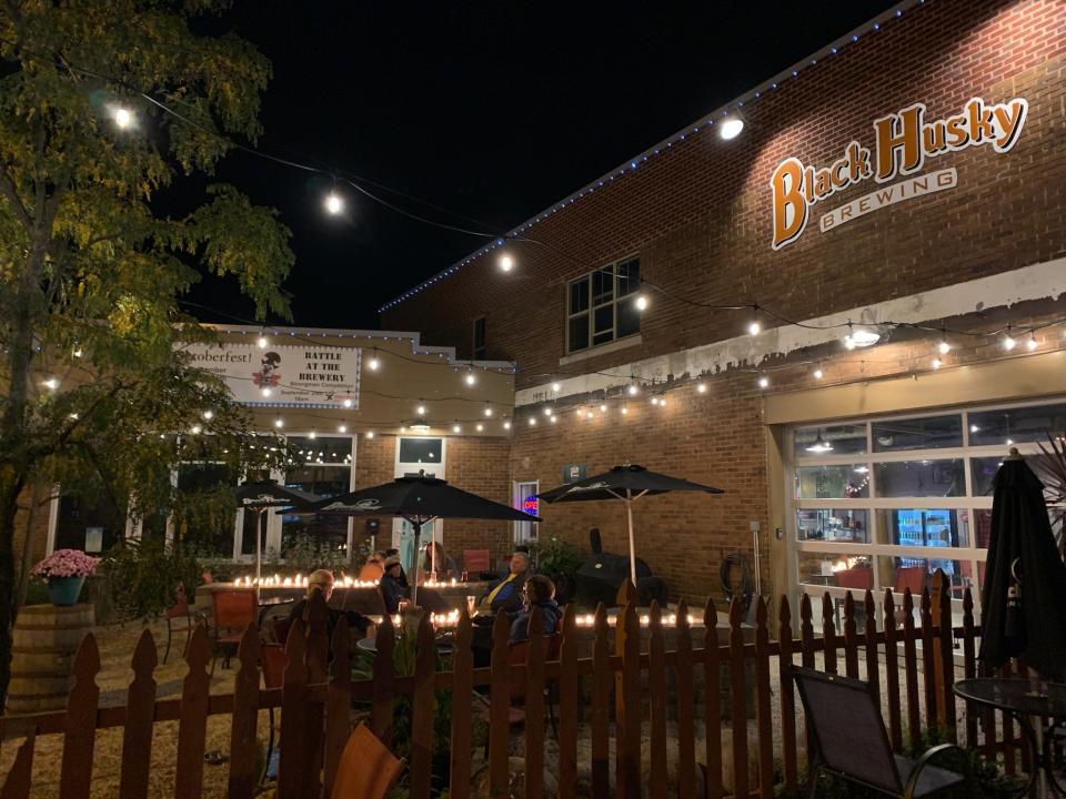 Black Husky Brewing Company has to long outdoor tables that have propane fire pits for people to gather around and keep warm