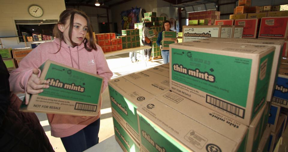 Ten-year-old Lily Helms pulls cases of Girl Scout cookies early Saturday morning, Jan. 13, 2024, at the Gastonia Farmers Market on East Long Avenue.