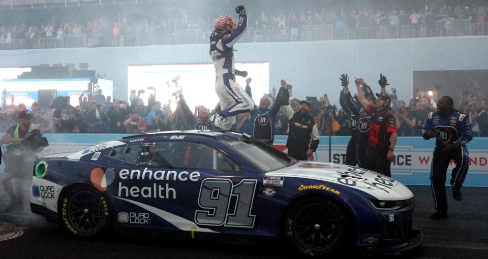 Shane van Gisbergen stands atop his No. 91 Trackhouse Racing Chevrolet in Victory Lane as his pit crew celebrates around him following his 2023 Chicago Street Race victory.