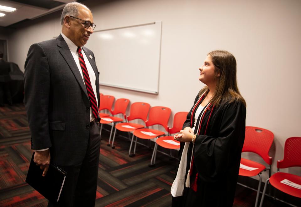 Neville Pinto, the 30th president of the University of Cincinnati, talks with Hattie Martin, 22, one of UC's graduates at Fifth Third Arena, Friday, April 29, 2022.