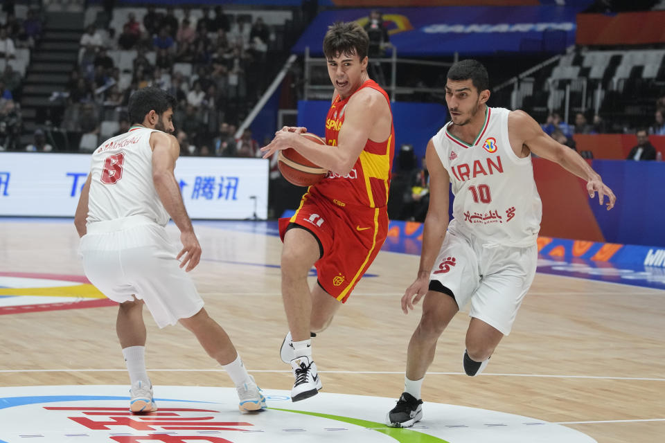 FILE - Spain guard Juan Nunez (24) drives past Iran forward Piter Girgoorian (10) and Iran guard Behnam Yakhchali (8) during the Basketball World Cup group G match between Spain and Iran at the Indonesia Arena stadium in Jakarta, Indonesia, on Aug. 30, 2023. (AP Photo/Dita Alangkara, File)