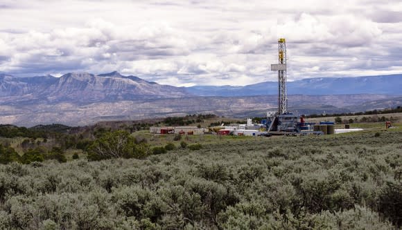 A drilling rig with mountains in the background.