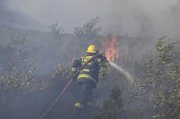 A fire rages on the slopes of Table Mountain, in Cape Town South Africa, Monday, April 19, 2021. Residents were evacuated from Cape Town neighborhoods Monday as a huge fire spreading on the slopes of the city's famed Table Mountain was fanned by strong winds overnight and houses came under threat. (AP Photo)