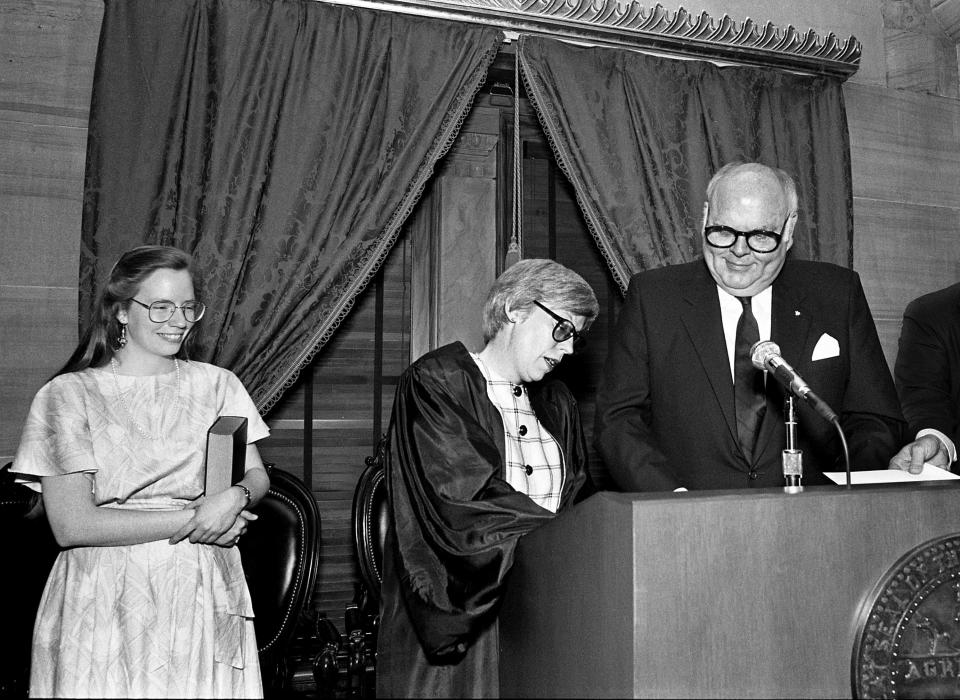 Carran Daughtrey, left, smiles as her mother, Judge Martha Craig Daughtrey, adds her signature to documents April 23, 1990, marking her swearing in by Gov. Ned McWherter as the first woman member of the Tennessee Supreme Court. More than 400 attended the ceremony in the state Capitol.