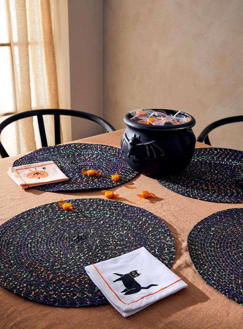 the confetti placemats on a table with candy and napkins