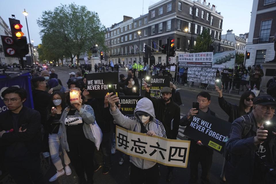 People attend a candlelight vigil outside the Chinese embassy in London, Sunday, June 4, 2023 to mark the anniversary of China's bloody 1989 crackdown on pro-democracy protests in Beijing's Tiananmen Square. (AP Photo/Kin Cheung)