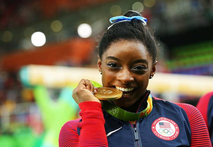 Simone Biles taking a bite out of her gold medal