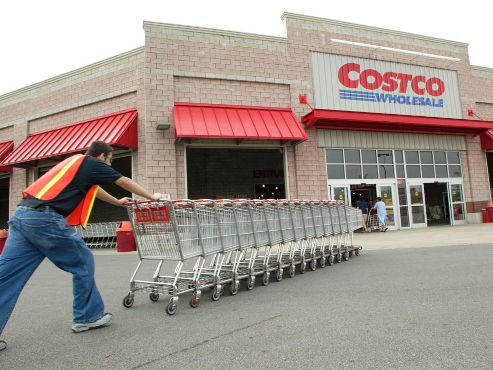 Costco, man pushing a cart in front of store