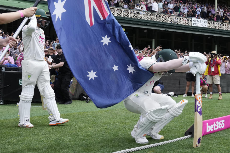Australia's David Warner, right, prepares to take to the field to bat in his final test before retiring, on the fourth day of their cricket test match against Pakistan in Sydney, Saturday, Jan. 6, 2024. (AP Photo/Rick Rycroft)