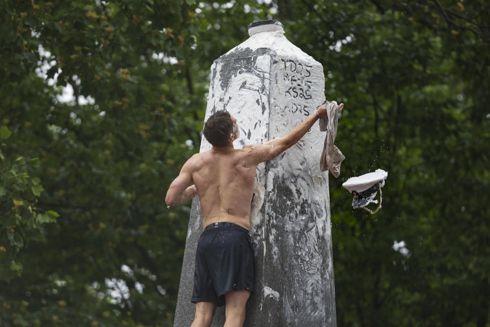Plebe Ben Leisegang, of California, attempts to place an upperclassman's hat atop the Herndon Monument at the U.S. Naval Academy, Wednesday, May 15, 2024, in Annapolis, Md. Freshmen, known as Plebes, participate in the climb to celebrate finishing their first year at the academy. The climb was completed in two hours, nineteen minutes and eleven seconds. (AP Photo/Tom Brenner)