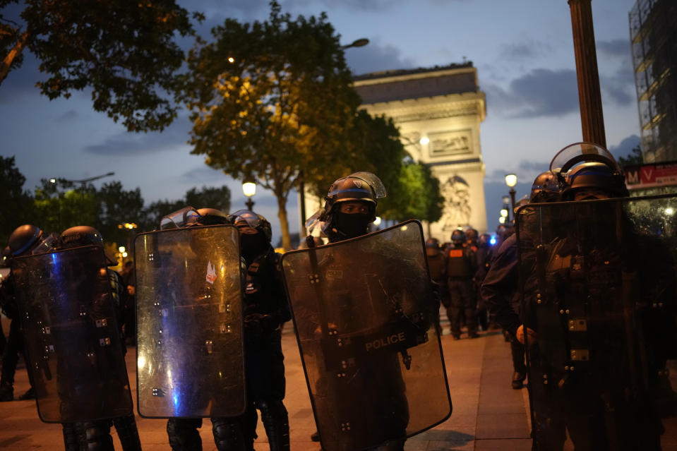 Police officers patrol in front of the Arc de Triomphe on the Champs Elysees in Paris, Saturday, July 1, 2023. President Emmanuel Macron on Saturday scrapped an official trip to Germany after a fourth straight night of rioting and looting across France in defiance of a massive police deployment. Hundreds turned out for the burial of the 17-year-old whose killing by police triggered the unrest. (AP Photo/Christophe Ena)