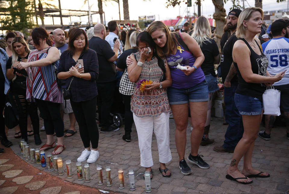 FILE - In this Monday, Oct. 1, 2018 file photo people embrace before a ceremony at a memorial garden, on the anniversary of the mass shooting a year earlier, in Las Vegas. Two years after a shooter rained gunfire on country music fans from a high-rise Las Vegas hotel, MGM Resorts International reached a settlement that could pay up to $800 million to families of the 58 people who died and hundreds of others who were injured, attorneys announced Thursday, Oct. 3, 2019. (AP Photo/John Locher,File)