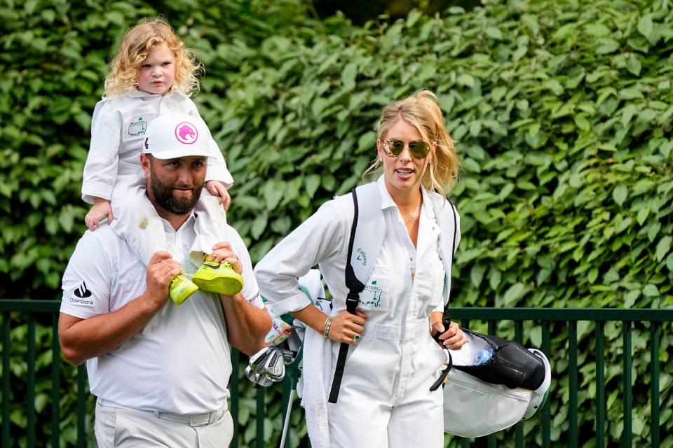 Defending Masters champion Jon Rahm walks with his wife, Kelley Cahill, and his son, Kepa, during the Par 3 Contest at The Masters on Wednesday, April 10.