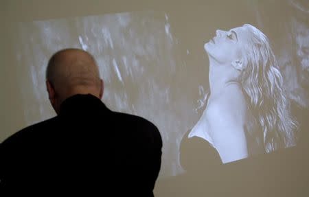 A visitor looks at Swedish actress Anita Ekberg playing in Federico Fellini's movie "La Dolce Vita" displayed as part of an exhibition at Rome's Macro Museum October 29, 2010. REUTERS/Alessia Pierdomenico