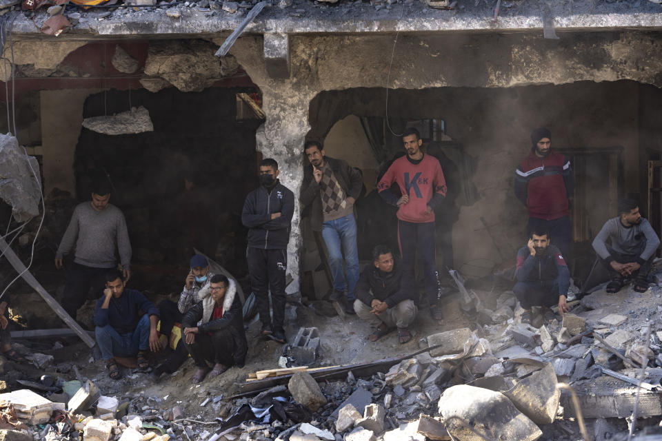 Palestinians search for bodies and survivors in the rubble of a residential building destroyed in an Israeli airstrike, in Rafah, southern Gaza Strip, Tuesday, Dec. 19, 2023. (AP Photo/Fatima Shbair)