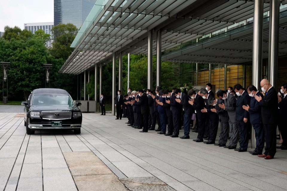 A hearse transporting the body of Japan's former prime minister Shinzo Abe makes a brief visit to the Prime Minister's Office after his funeral ceremony, as Japan's Prime Minister Fumio Kishida, officials and employees offer prayers in Tokyo on July 12, 2022. (Photo by Eugene Hoshiko / POOL / AFP) (Photo by EUGENE HOSHIKO/POOL/AFP via Getty Images)