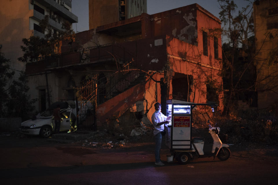 A man sells coffee in a neighborhood near the site of last week's massive explosion in Beirut, Lebanon, Friday, Aug. 14, 2020. (AP Photo/Felipe Dana)