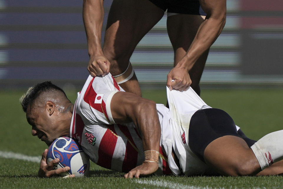 Japan's Lomano Lemeki, below, is tackled by Argentina's Tomas Lavanini during the Rugby World Cup Pool D match between Japan and Argentina at the Stade de la Beaujoire in Nantes, western France, Sunday, Nov. 8, 2023. (AP Photo/Lewis Joly)