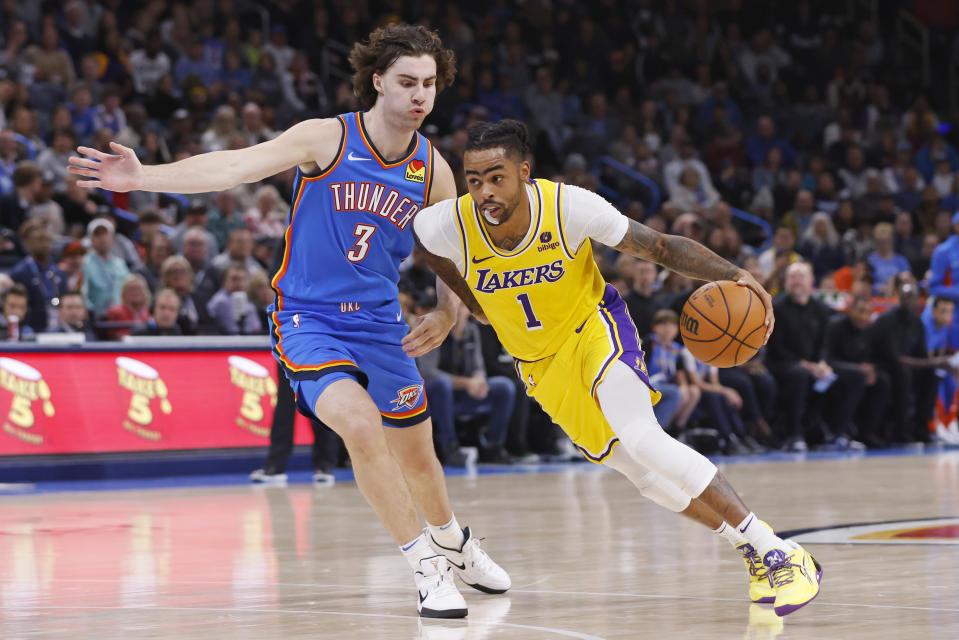 Los Angeles Lakers guard D'Angelo Russell (1) drives against Oklahoma City Thunder guard Josh Giddey (3) during the first half of an NBA basketball game Thursday, Nov. 30, 2023, in Oklahoma City. (AP Photo/Nate Billings)