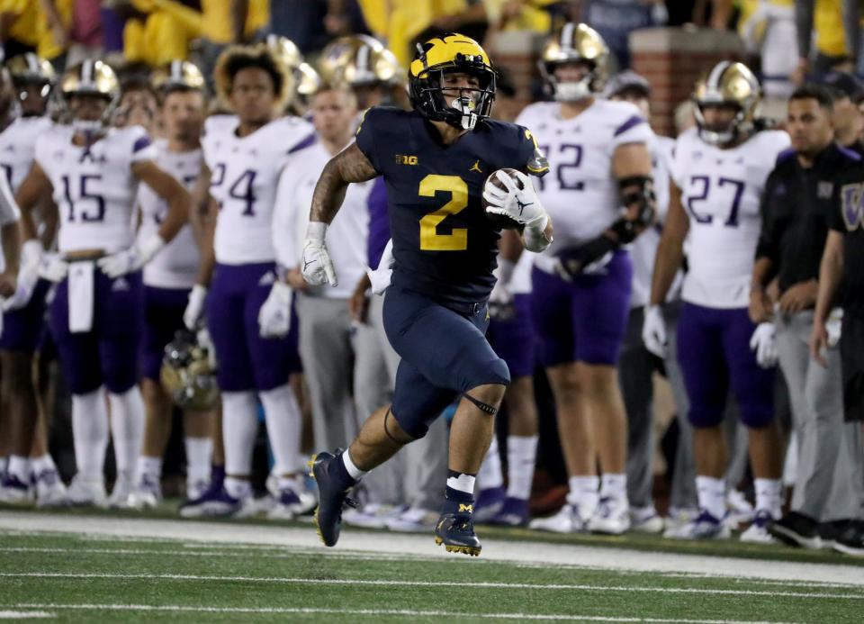 Michigan Wolverines running back Blake Corum (2) runs by Washington Huskies defensive back Kamren Fabiculanan (31) for a touchdown Saturday, Sept. 11, 2021 at Michigan Stadium.