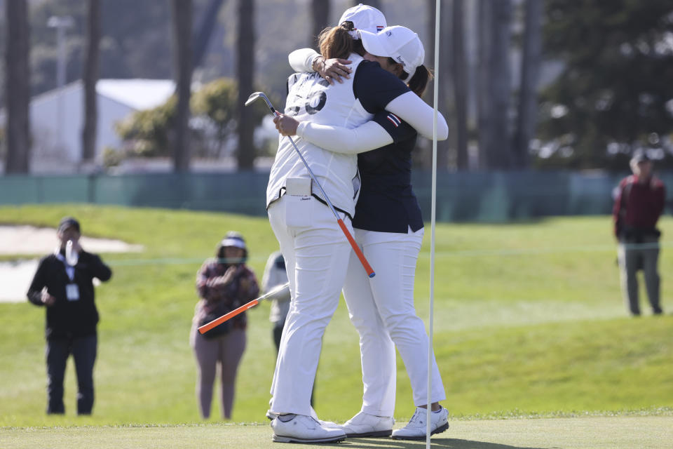 Thailand's Ariya Jutanugarn, left, and Moriya Jutanugarn hug on the 15th green after winning the International Crown match play golf tournament in San Francisco, Sunday, May 7, 2023. (AP Photo/Benjamin Fanjoy)