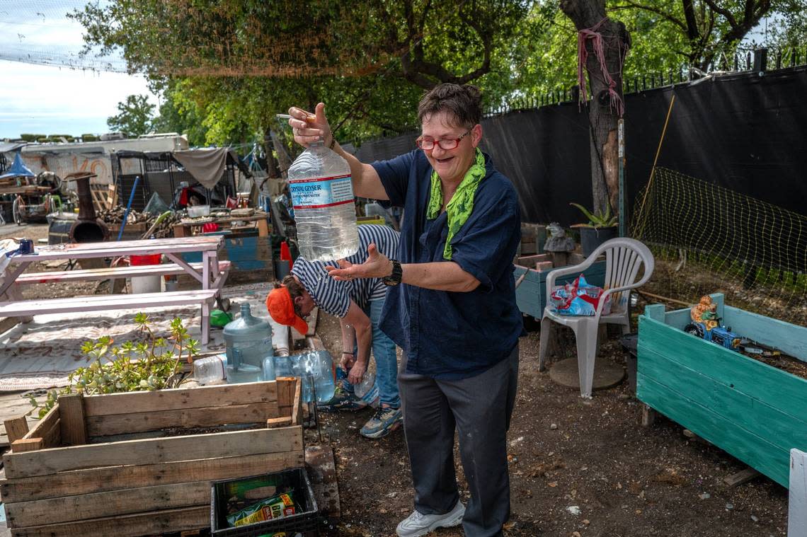 Joyce Williams smiles as she explains lask week that she and her wife Sharon Jones made pin holes in plastic water bottles to create a drip system in their vegetable garden at Camp Resolution. Water and electricity are not available at the self-governing encampment, but this is one of their improvised solutions for sustainable farming.