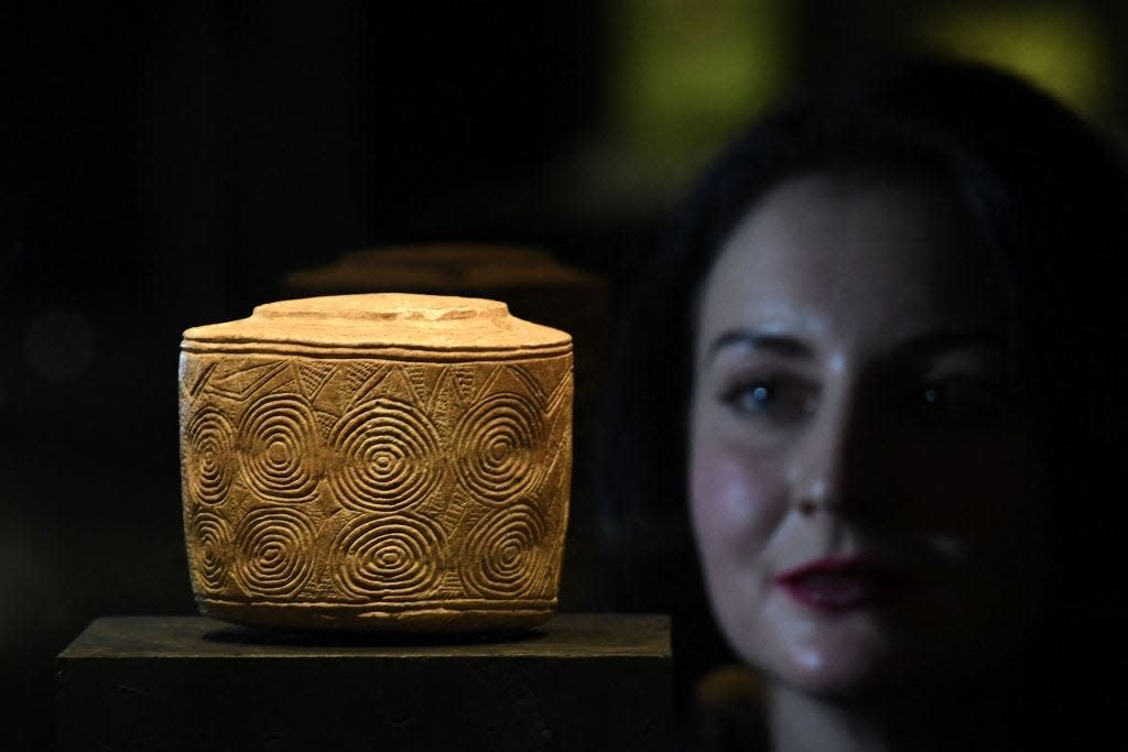 An ancient drum in the background with a woman in front out of focus