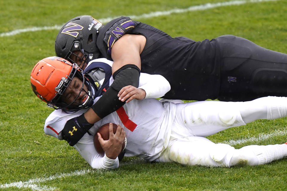Illinois quarterback Isaiah Williams, left, is tackled by Northwestern defensive end Earnest Brown IV during the first half of an NCAA college basketball game in Evanston, Ill., Saturday, Dec. 12, 2020. (AP Photo/Nam Y. Huh)