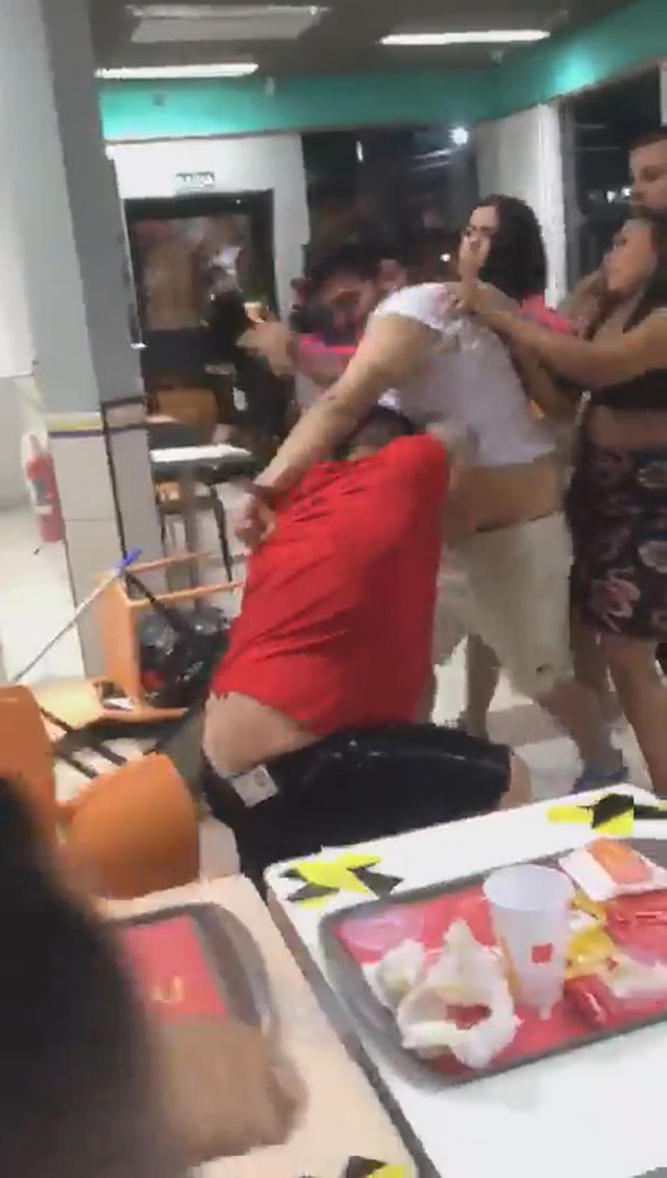 Two men fight in McDonald's. 