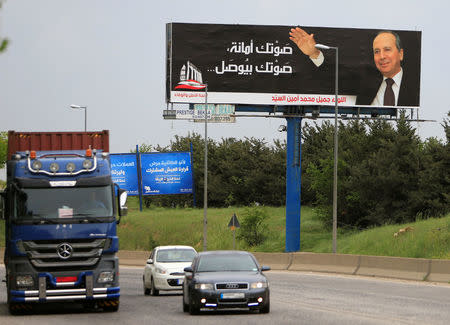 Cars drive past a campaign poster for Jamil al-Sayyed at Dahr al-Baidar area in Lebanon's eastern Bekaa Valley, Lebanon April 25, 2018. REUTERS/Ali Hashisho