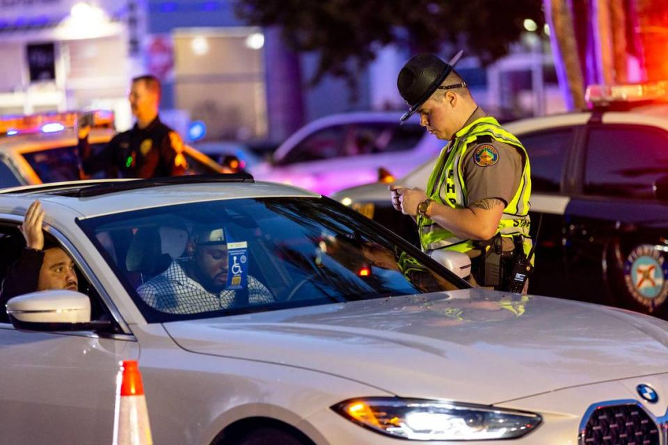 A Florida Highway Patrol officer interacts with a motorist during a DUI checkpoint on Fifth Street between Meridian and Washington Avenues in Miami Beach, on March 25, 2023.