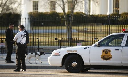 Members of the U.S. Secret Service keep watch at the fence surrounding the White House in Washington March 12, 2015. REUTERS/Kevin Lamarque