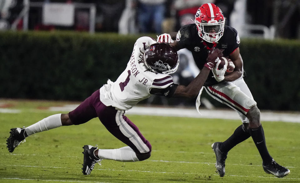 FILE -Mississippi State cornerback Martin Emerson, left, tackles Georgia wide receiver George Pickens during the first half of an NCAA college football game Saturday, Nov. 21, 2020, in Athens, Ga. Georgia wide receiver George Pickens still has a chance to be a major contributor for the Bulldogs this season. The junior who was expected to be third-ranked Georgia's go-to receiver before he tore the ACL in his right knee during spring practice will be available Friday, Dec. 31, 2021 for the College Football Playoff semifinal at the Orange Bowl against No. 2 Michigan. (AP Photo/Brynn Anderson, File)