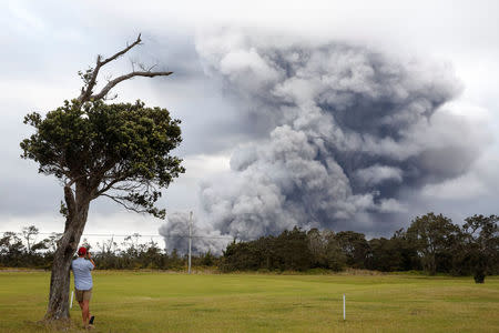 A man watches as ash erupts from the Halemaumau crater near the community of Volcano during ongoing eruptions of the Kilauea Volcano in Hawaii, U.S., May 15, 2018. REUTERS/Terray Sylvester